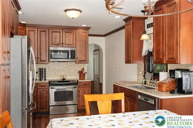 7438 Rte 309, Lynn Twp, PA 18066 - kitchen featuring appliances with stainless steel finishes, arched walkways, backsplash, brown cabinetry, and ornamental molding