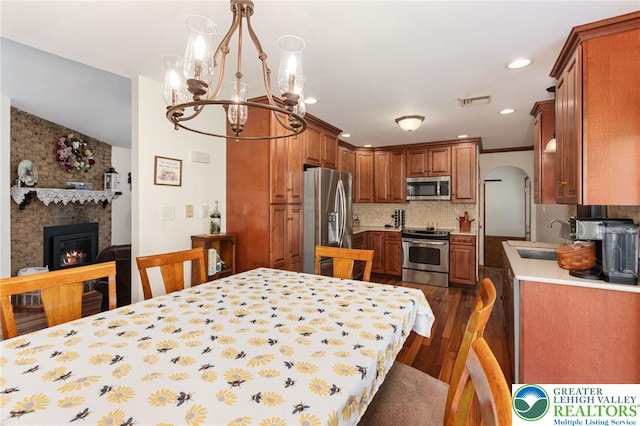 7438 Rte 309, Lynn Twp, PA 18066 - dining area with a chandelier, a brick fireplace, dark wood-style flooring, arched walkways, and recessed lighting