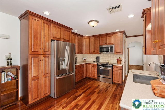 7438 Rte 309, Lynn Twp, PA 18066 - kitchen featuring appliances with stainless steel finishes, light countertops, dark wood-style floors, arched walkways, and recessed lighting