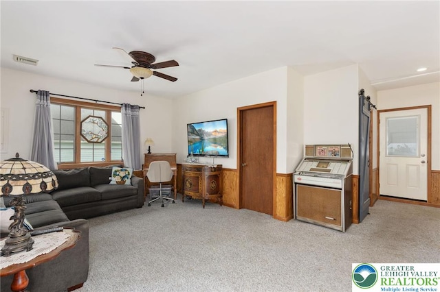 7438 Rte 309, Lynn Twp, PA 18066 - living area with light colored carpet, ceiling fan, a wainscoted wall, a barn door, and wooden walls