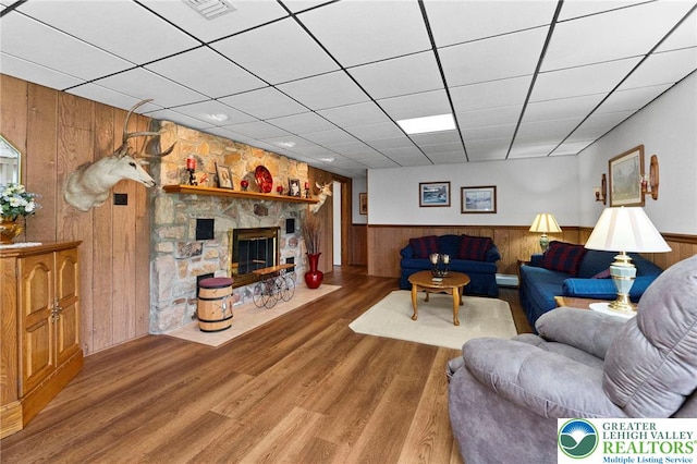 4661 Hillside Rd, Coplay Boro, PA 18037 - living room featuring wooden walls, wainscoting, wood finished floors, a paneled ceiling, and a fireplace