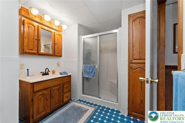 4661 Hillside Rd, Coplay Boro, PA 18037 - bathroom featuring a shower stall, vanity, a wainscoted wall, a paneled ceiling, and tile walls