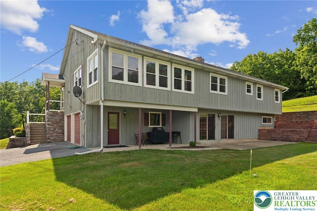 4661 Hillside Rd, Coplay Boro, PA 18037 - rear view of property featuring a yard, asphalt driveway, a patio area, and a garage
