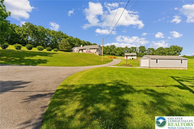 4661 Hillside Rd, Coplay Boro, PA 18037 - view of grassy yard featuring a detached garage, an outbuilding, and driveway