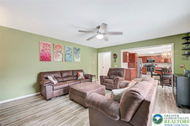5117 Hounds Ear Rd, Coolbaugh Twp, PA 18466 - living room with light wood-type flooring, a ceiling fan, and a chandelier