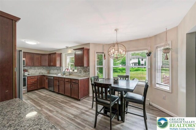 5117 Hounds Ear Rd, Coolbaugh Twp, PA 18466 - kitchen featuring stainless steel appliances, light wood-style flooring, tasteful backsplash, and light stone counters
