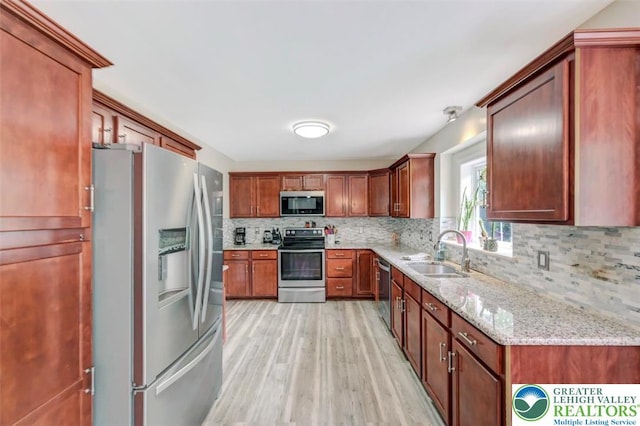 5117 Hounds Ear Rd, Coolbaugh Twp, PA 18466 - kitchen with appliances with stainless steel finishes, light wood finished floors, decorative backsplash, and light stone countertops