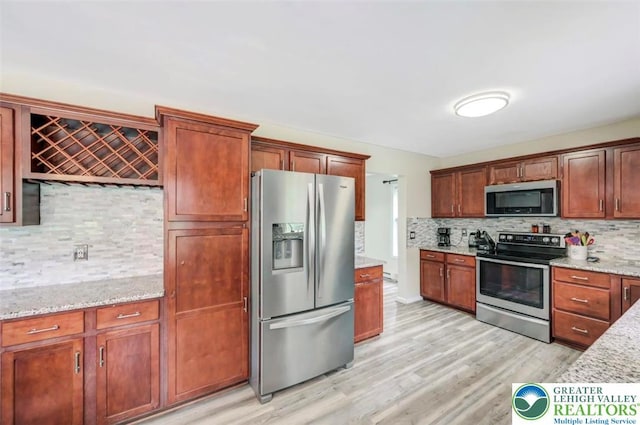 5117 Hounds Ear Rd, Coolbaugh Twp, PA 18466 - kitchen with stainless steel appliances, backsplash, light wood-style flooring, and light stone counters