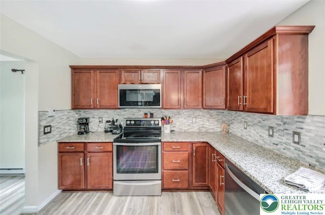 5117 Hounds Ear Rd, Coolbaugh Twp, PA 18466 - kitchen featuring appliances with stainless steel finishes, light wood-style flooring, light stone countertops, and tasteful backsplash