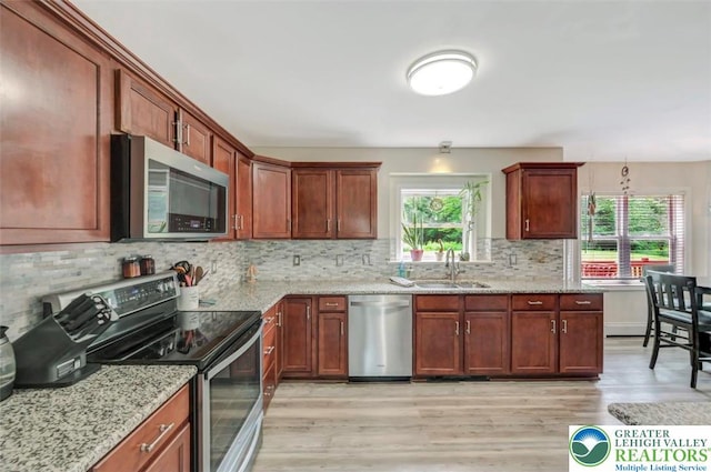 5117 Hounds Ear Rd, Coolbaugh Twp, PA 18466 - kitchen with stainless steel appliances, light wood finished floors, decorative backsplash, and light stone countertops