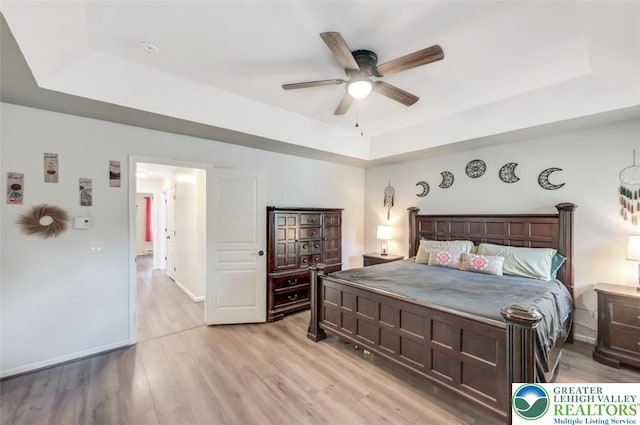 5117 Hounds Ear Rd, Coolbaugh Twp, PA 18466 - bedroom featuring a tray ceiling, light wood finished floors, and ceiling fan