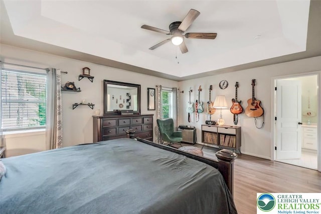 5117 Hounds Ear Rd, Coolbaugh Twp, PA 18466 - bedroom with a raised ceiling, light wood-type flooring, connected bathroom, and ceiling fan