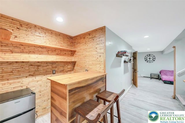5117 Hounds Ear Rd, Coolbaugh Twp, PA 18466 - indoor dry bar featuring light wood-style floors, recessed lighting, wooden walls, and fridge