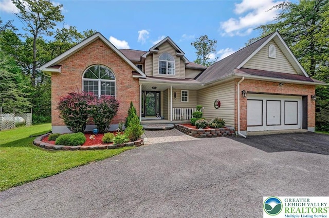 5117 Hounds Ear Rd, Coolbaugh Twp, PA 18466 - view of front facade with asphalt driveway, covered porch, an attached garage, brick siding, and a front lawn