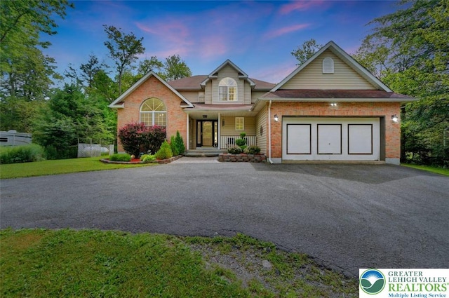 5117 Hounds Ear Rd, Coolbaugh Twp, PA 18466 - view of front of property with asphalt driveway, covered porch, brick siding, and an attached garage