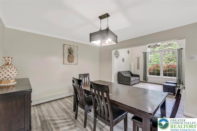 5117 Hounds Ear Rd, Coolbaugh Twp, PA 18466 - dining room featuring a baseboard heating unit, light wood-style flooring, and crown molding