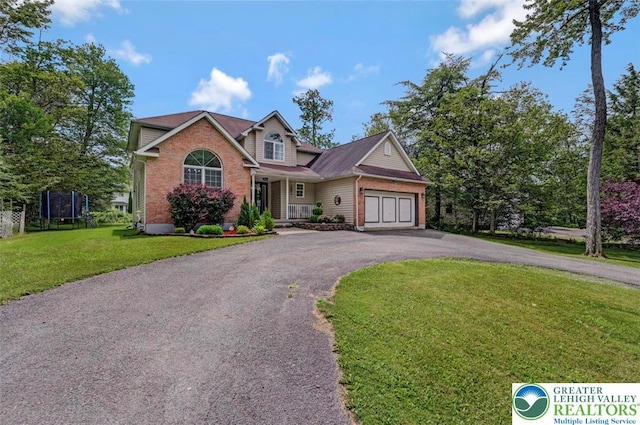 5117 Hounds Ear Rd, Coolbaugh Twp, PA 18466 - view of front of property with asphalt driveway, brick siding, an attached garage, a front lawn, and a trampoline
