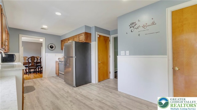 2930 Green Pond, Palmer Twp, PA 18045 - kitchen featuring freestanding refrigerator, light countertops, light wood finished floors, brown cabinets, and stove