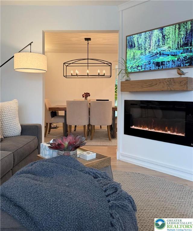 12 Concord Ct, Easton, PA 18040 - living room featuring a chandelier, wood finished floors, and a glass covered fireplace