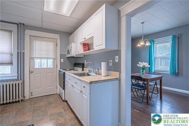 858 Radclyffe St, Bethlehem City, PA 18017 - kitchen featuring white appliances, radiator, healthy amount of natural light, a chandelier, and a drop ceiling