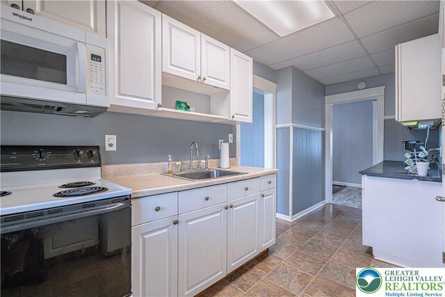 858 Radclyffe St, Bethlehem City, PA 18017 - kitchen featuring white appliances, white cabinetry, open shelves, light stone finish floors, and a paneled ceiling
