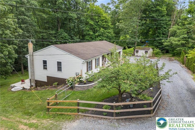 2954 Avery Rd, Washington Twp, PA 18080 - view of front of house featuring a storage unit, a garden, a forest view, and gravel driveway