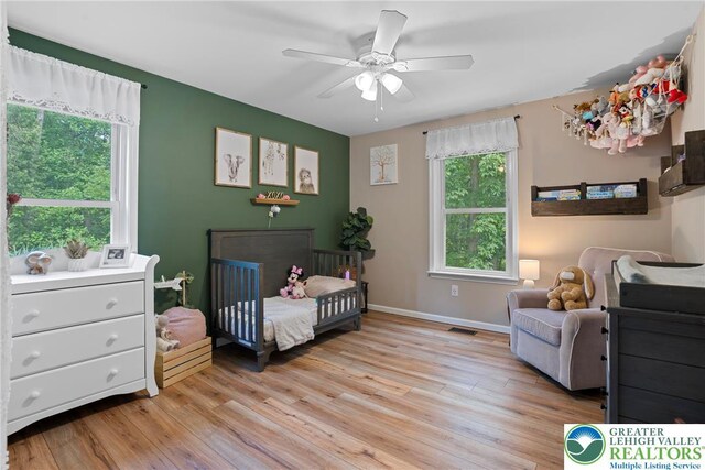 2954 Avery Rd, Washington Twp, PA 18080 - bedroom featuring multiple windows, light wood-type flooring, and a crib