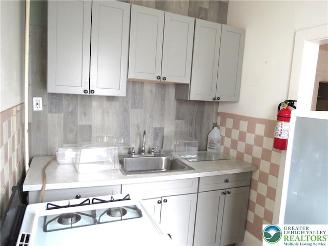 151 W Nesquehoning St, Easton, PA 18042 - kitchen featuring tile walls, light countertops, wainscoting, and gas range gas stove