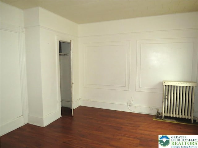 151 W Nesquehoning St, Easton, PA 18042 - unfurnished bedroom with radiator heating unit, dark wood-type flooring, and a closet