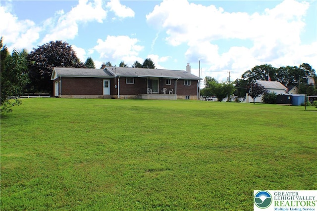 1321 Bushkill Center Rd, Bushkill Twp, PA 18091 - back of house with a yard, brick siding, a chimney, and a garage