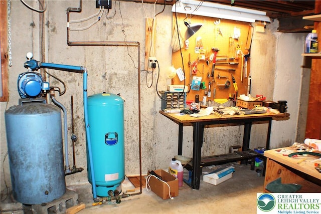 1321 Bushkill Center Rd, Bushkill Twp, PA 18091 - unfinished below grade area featuring a water pressure tank, a workshop area, and a water softener