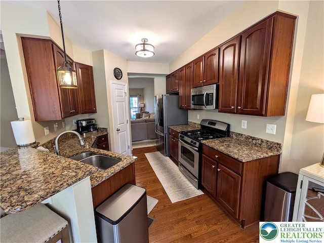 119 Gray Dr, Allen Twp, PA 18067 - kitchen featuring appliances with stainless steel finishes, dark wood finished floors, dark stone counters, and a kitchen breakfast bar