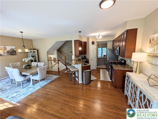 119 Gray Dr, Allen Twp, PA 18067 - kitchen featuring range with gas stovetop, stainless steel microwave, dark wood-style floors, and a breakfast bar area