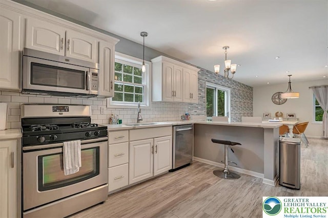 5 Flagstone Ln, East Stroudsburg, PA 18302 - kitchen featuring stainless steel appliances, light wood-style floors, tasteful backsplash, a chandelier, and light countertops