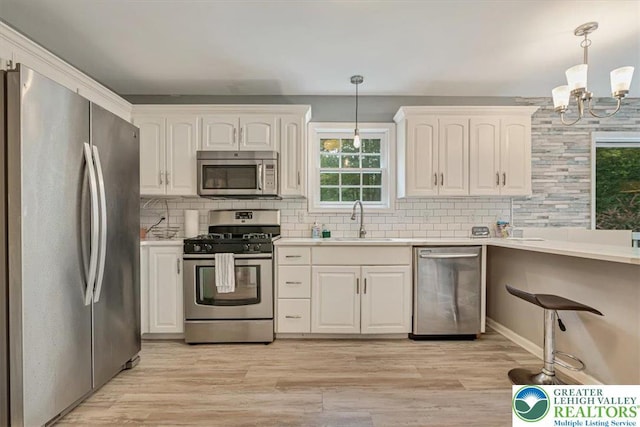 5 Flagstone Ln, East Stroudsburg, PA 18302 - kitchen featuring appliances with stainless steel finishes, decorative backsplash, a chandelier, and white cabinetry