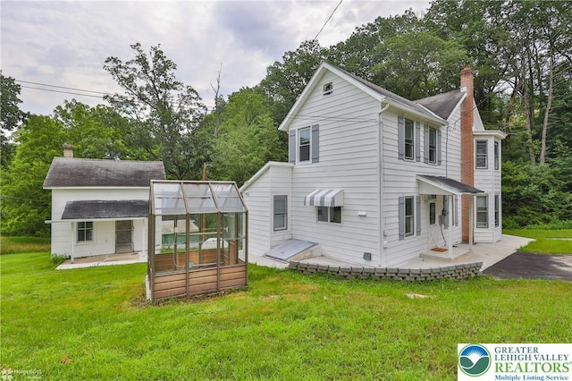 1911 Echo Rd, North Whitehall Twp, PA 18080 - back of house featuring a chimney, a lawn, and view of wooded area
