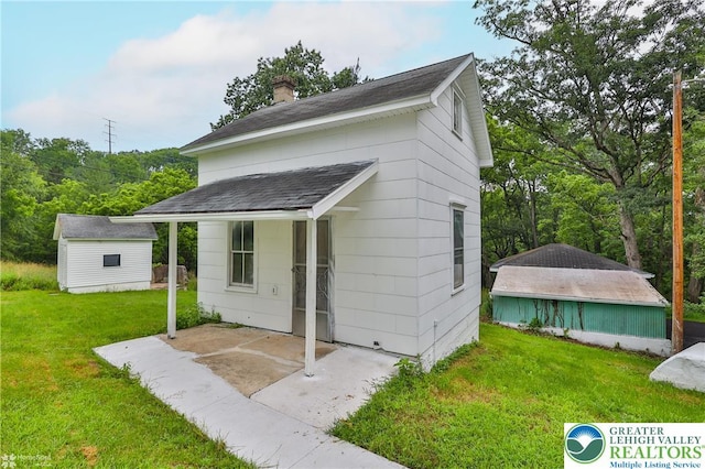 1911 Echo Rd, North Whitehall Twp, PA 18080 - view of front facade with an outbuilding, a front lawn, a chimney, and a patio