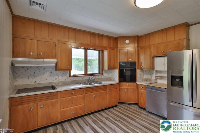1911 Echo Rd, North Whitehall Twp, PA 18080 - kitchen with black appliances, under cabinet range hood, brown cabinets, backsplash, and ornamental molding