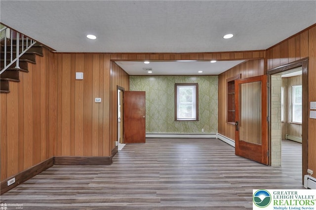 1911 Echo Rd, North Whitehall Twp, PA 18080 - unfurnished room featuring wood finished floors, stairway, a baseboard heating unit, healthy amount of natural light, and wallpapered walls