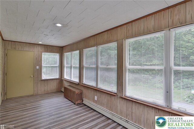 1911 Echo Rd, North Whitehall Twp, PA 18080 - unfurnished sunroom featuring radiator heating unit, a baseboard heating unit, wooden walls, and wood finished floors