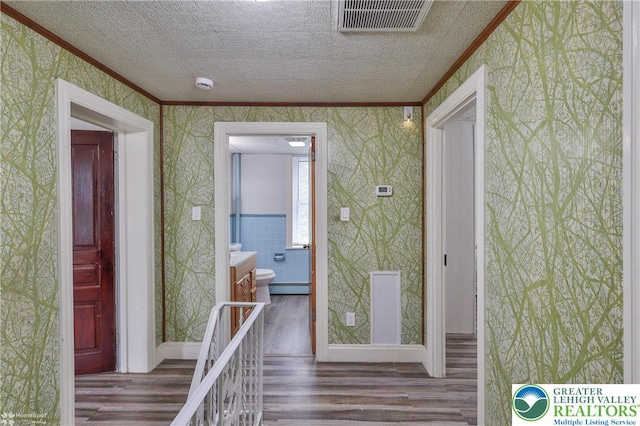 1911 Echo Rd, North Whitehall Twp, PA 18080 - corridor featuring ornamental molding, wallpapered walls, wood finished floors, a baseboard radiator, and a textured ceiling