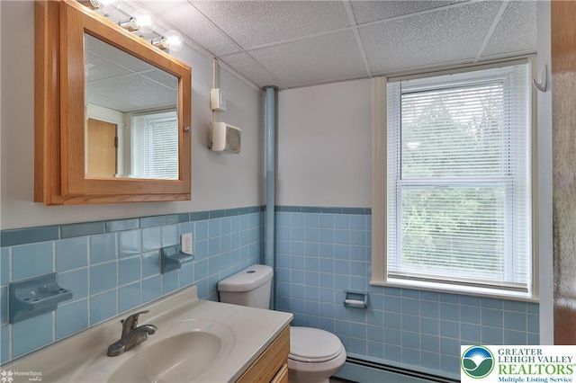 1911 Echo Rd, North Whitehall Twp, PA 18080 - bathroom with a baseboard radiator, a drop ceiling, tile walls, vanity, and a wainscoted wall