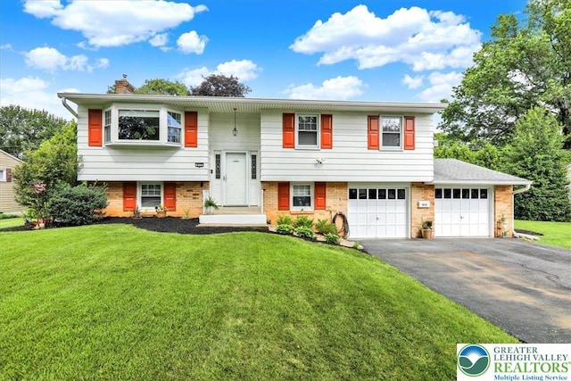 812 Miller St, Salisbury Twp, PA 18103 - split foyer home with driveway, a chimney, a front lawn, and an attached garage