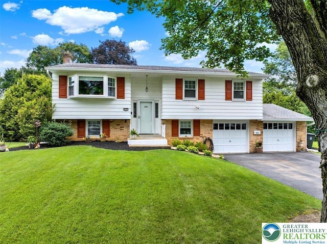 812 Miller St, Salisbury Twp, PA 18103 - raised ranch featuring asphalt driveway, a front lawn, a chimney, an attached garage, and brick siding