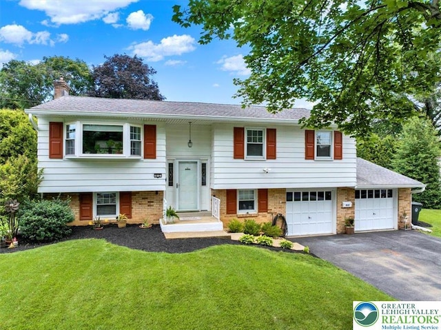 812 Miller St, Salisbury Twp, PA 18103 - split foyer home featuring a chimney, driveway, a front lawn, and brick siding