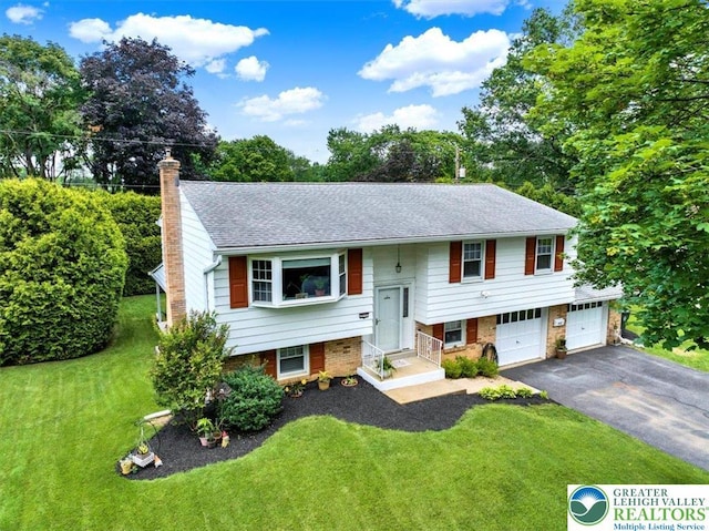 812 Miller St, Salisbury Twp, PA 18103 - split foyer home featuring an attached garage, driveway, a chimney, a front yard, and brick siding