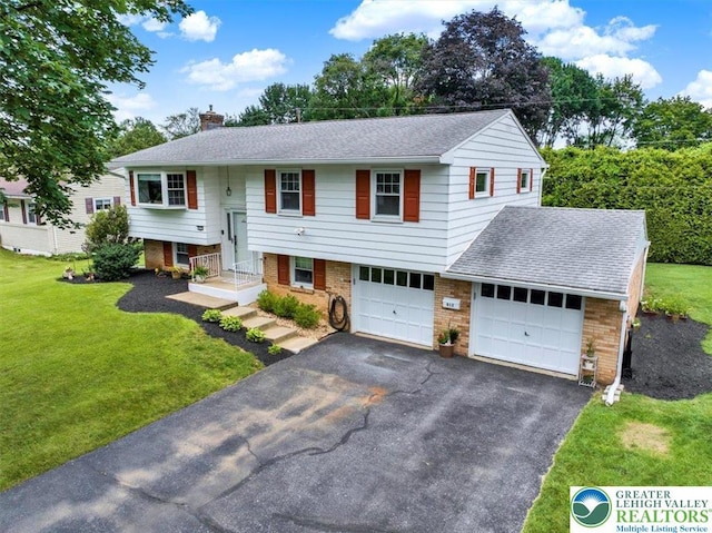 812 Miller St, Salisbury Twp, PA 18103 - raised ranch featuring asphalt driveway, a chimney, a front lawn, brick siding, and an attached garage
