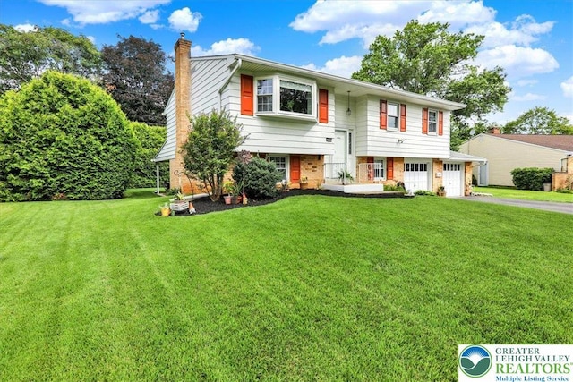 812 Miller St, Salisbury Twp, PA 18103 - split foyer home with a garage, a chimney, asphalt driveway, and a front yard