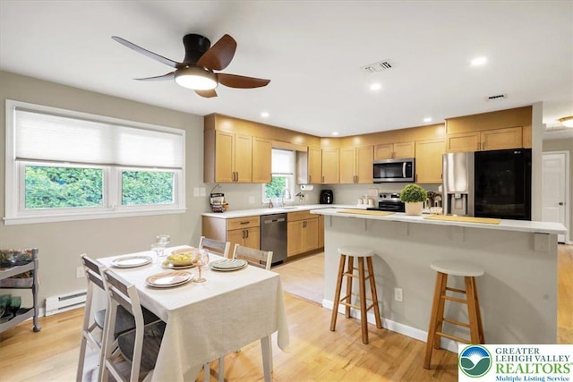 812 Miller St, Salisbury Twp, PA 18103 - kitchen with stainless steel appliances, a kitchen breakfast bar, light wood-style floors, light countertops, and light brown cabinetry