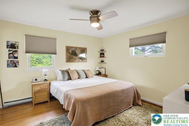 812 Miller St, Salisbury Twp, PA 18103 - bedroom featuring a baseboard radiator, multiple windows, wood finished floors, and a ceiling fan